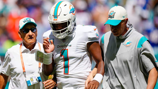 Dolphins QB Tua Tagovailoa walking off the field with team staff after sustaining an injury
